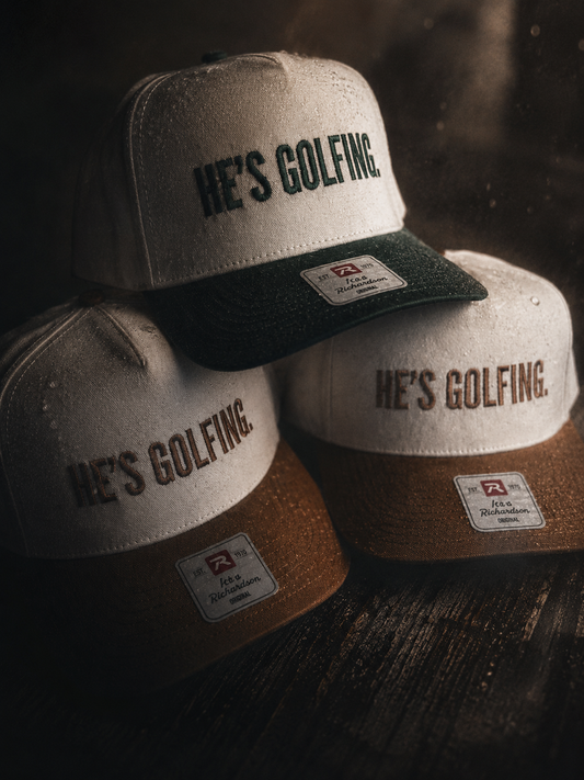 HE'S GOLFING trucker hat